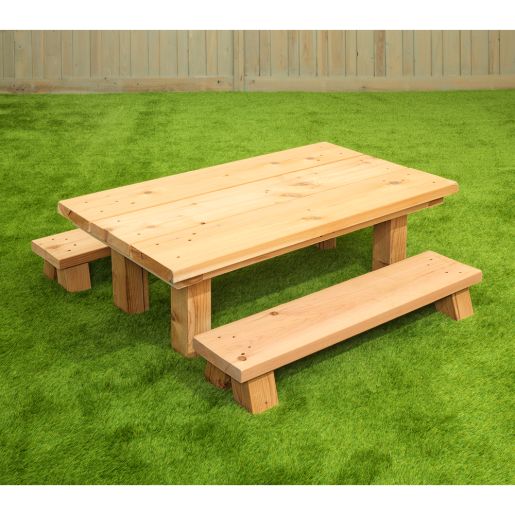 Wooden infant table and benches set displayed outdoors on grass