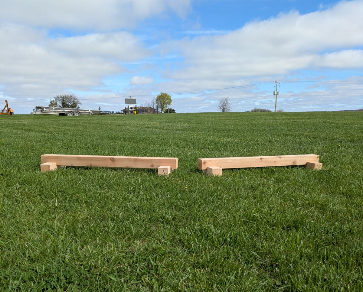 Two outdoor cedar balance beams arranged on grass for active play