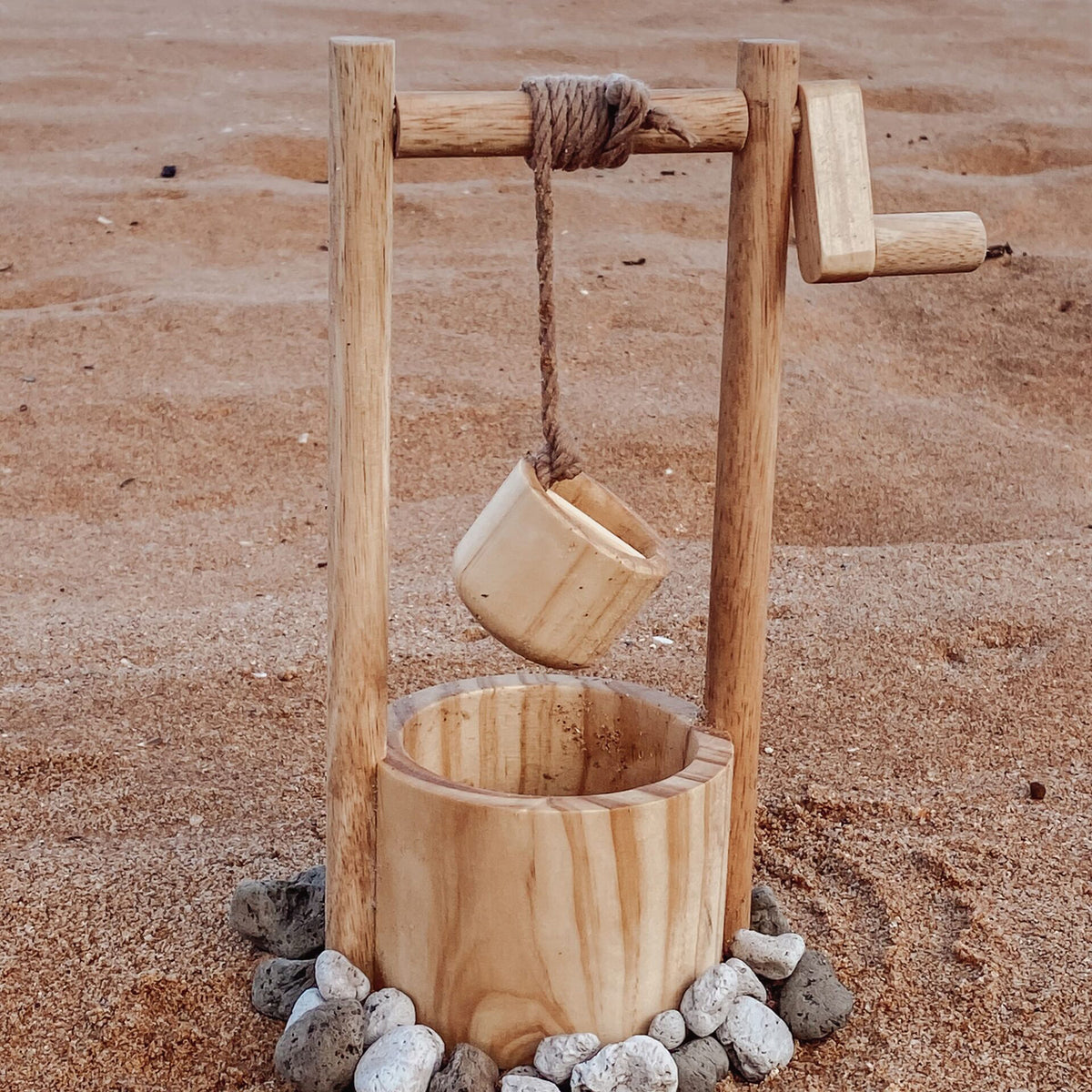 Wooden water well with bucket and rope arranged for outdoor play