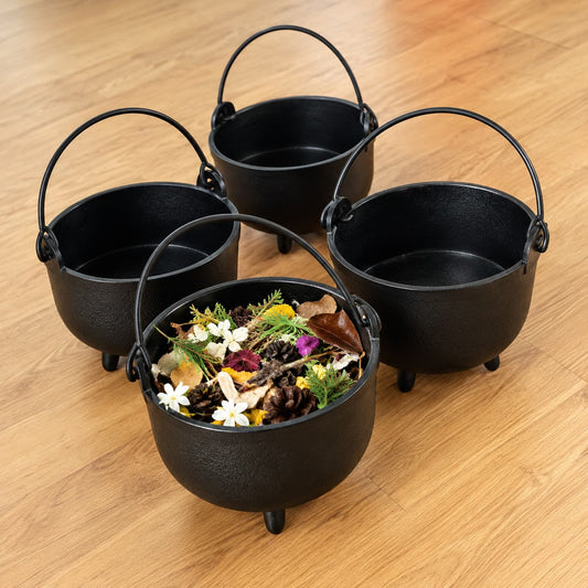 Four black cauldrons with natural materials for sensory and imaginative play