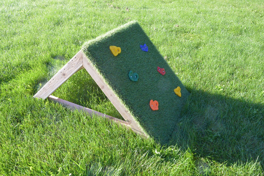 Textured green surface of the wooden Mini-Climber with colorful climbing grips.