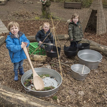 Children using the Potions & Concoctions outdoor mixing kit for sensory play