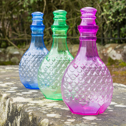 Three colorful TTS Giant Potion Bottles displayed outdoors for sensory play